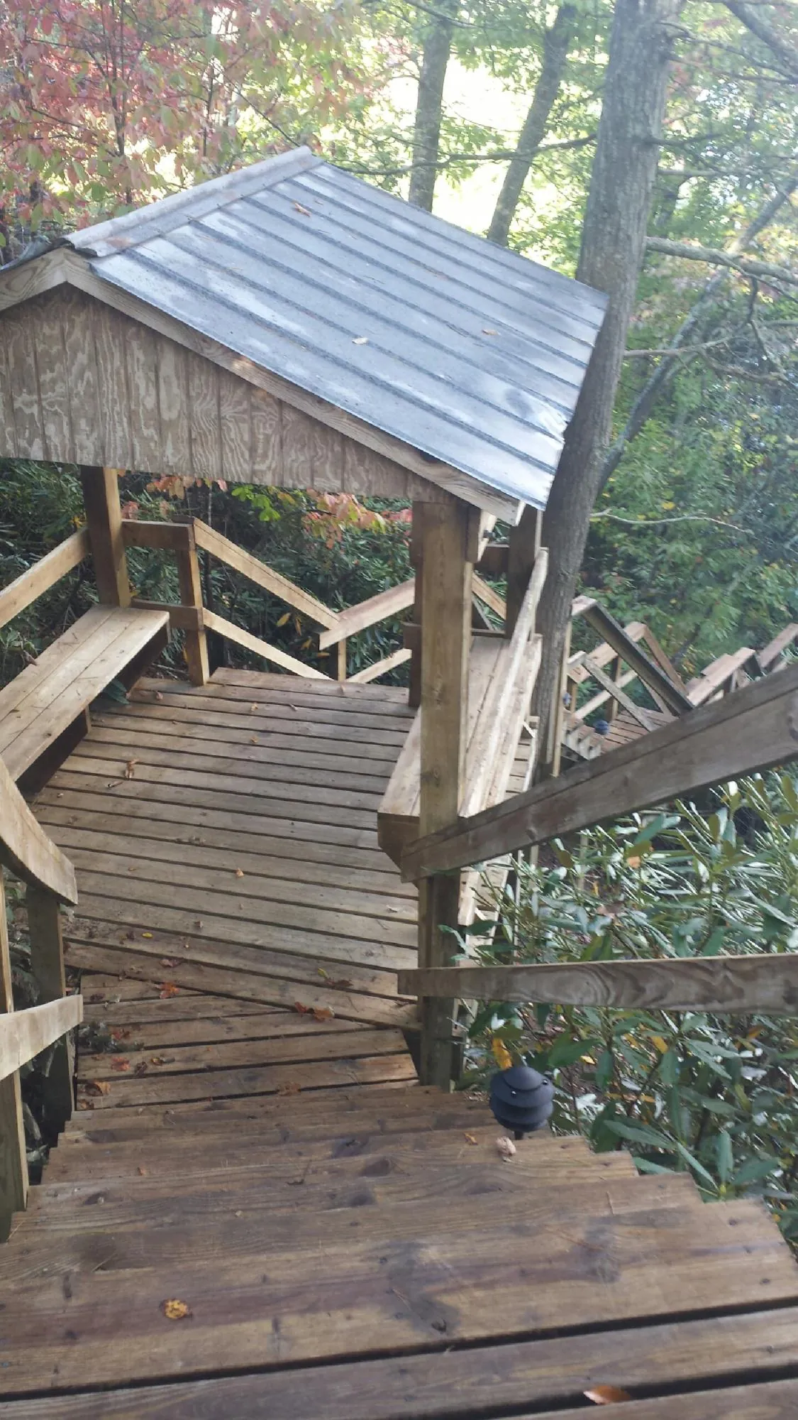 Metal roofed shelter over wooden steps on a wooded walkway — Skylight Repair & Installation work by our crew in Glen